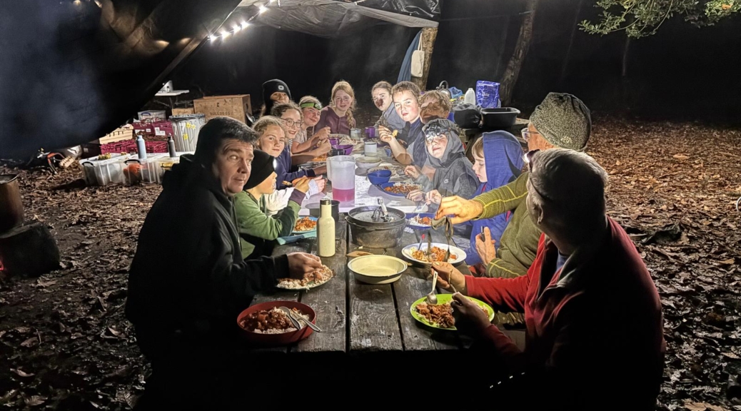 Scouts eating chicken stew in the dark